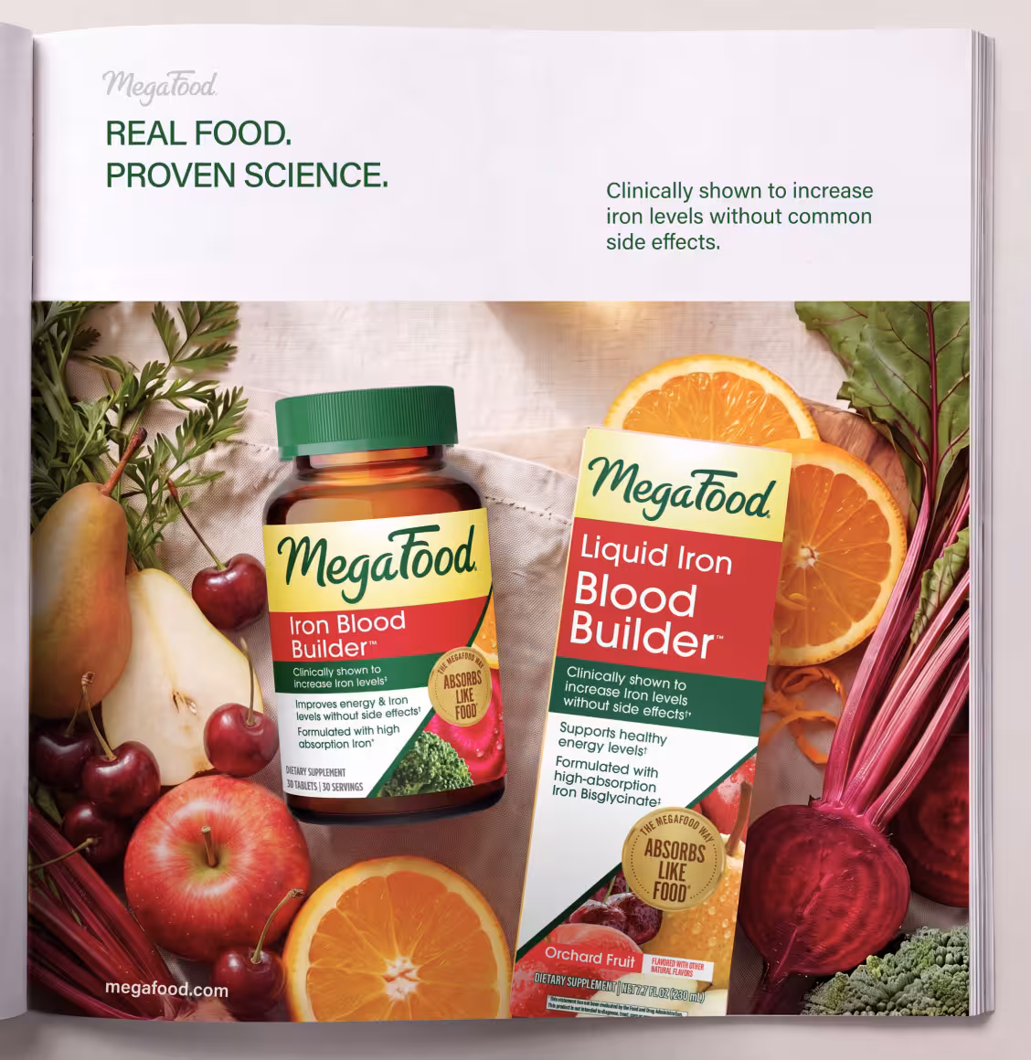 Advertisement for MegaFood Iron Blood Builder supplements, shown as bottles among fresh fruit and vegetables (orange slices, beets, greens).