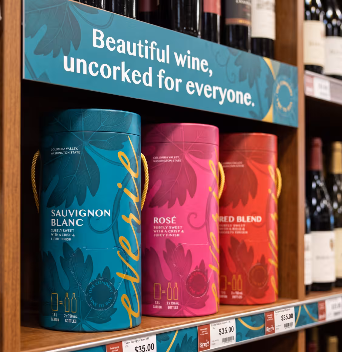 Teal Sauvignon Blanc tin on a shelf with pink Rosé and red blend tins beneath a sign reading 'Beautiful wine, uncorked for everyone.'