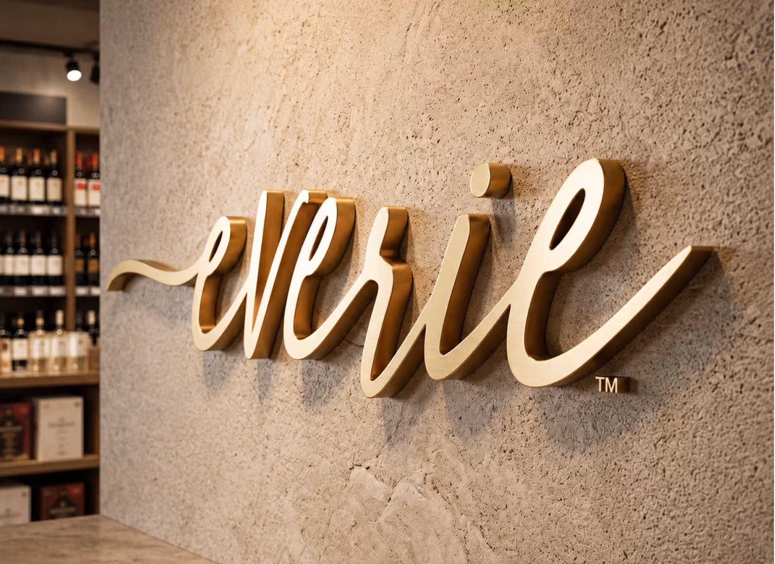 Gold cursive 'Wine' sign on a textured wall in a wine shop; shelves of bottles in the background.