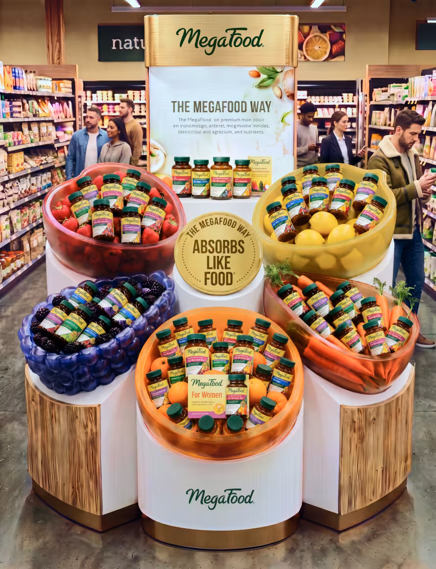 Megafood promotional display in a grocery store with fruit-shaped bowls filled with MegaFood bottles