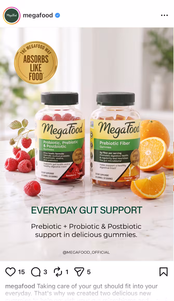 Two MegaFood probiotic gummies bottles on a marble surface with raspberries and orange slices, gold badge reading 'Absorbs Like Food'.