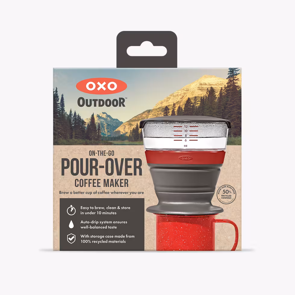 OXO Outdoor On-The-Go Pour-Over Coffee Maker in its packaging, with mountain scenery in the background.