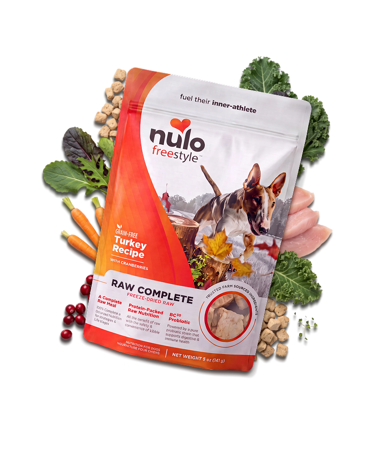 Dog food bag labeled Nulo FreeStyle Raw Complete Turkey Recipe with vegetables and kibble around it; shows raw turkey ingredients visualized as a product display.